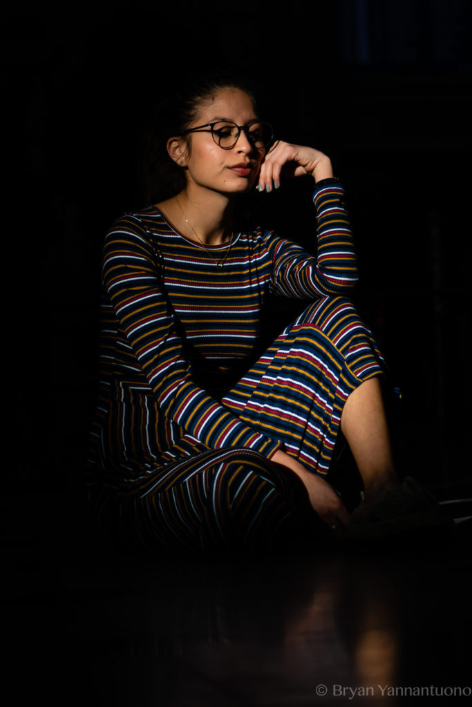 Portrait of a young woman in front of a black background