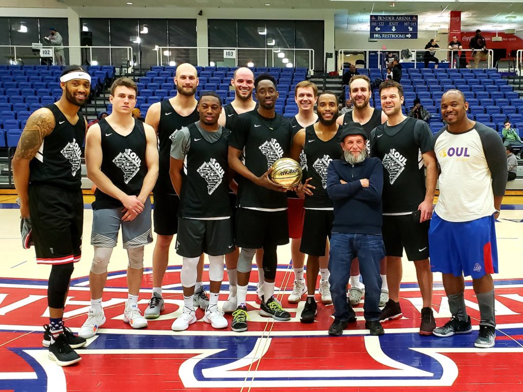 The winning basketball team stands with a trophy at center couty