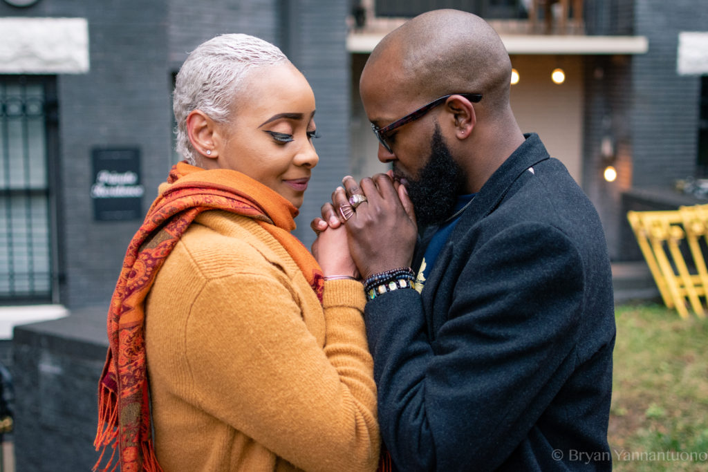 Portrait photography - a black man and woman hold hands lovingly