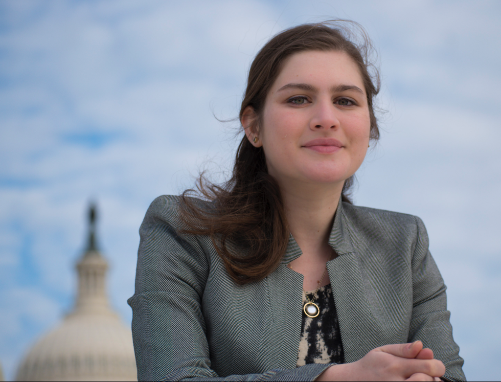 Professional headshot - woman dressed in grey stands in front of the United States Capitol in Washington, DC