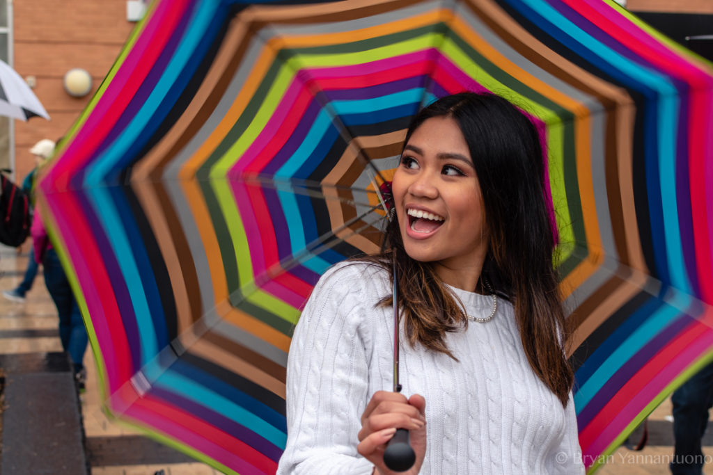 Portrait photography of a beautiful young woman smiles with a colorful umbrella