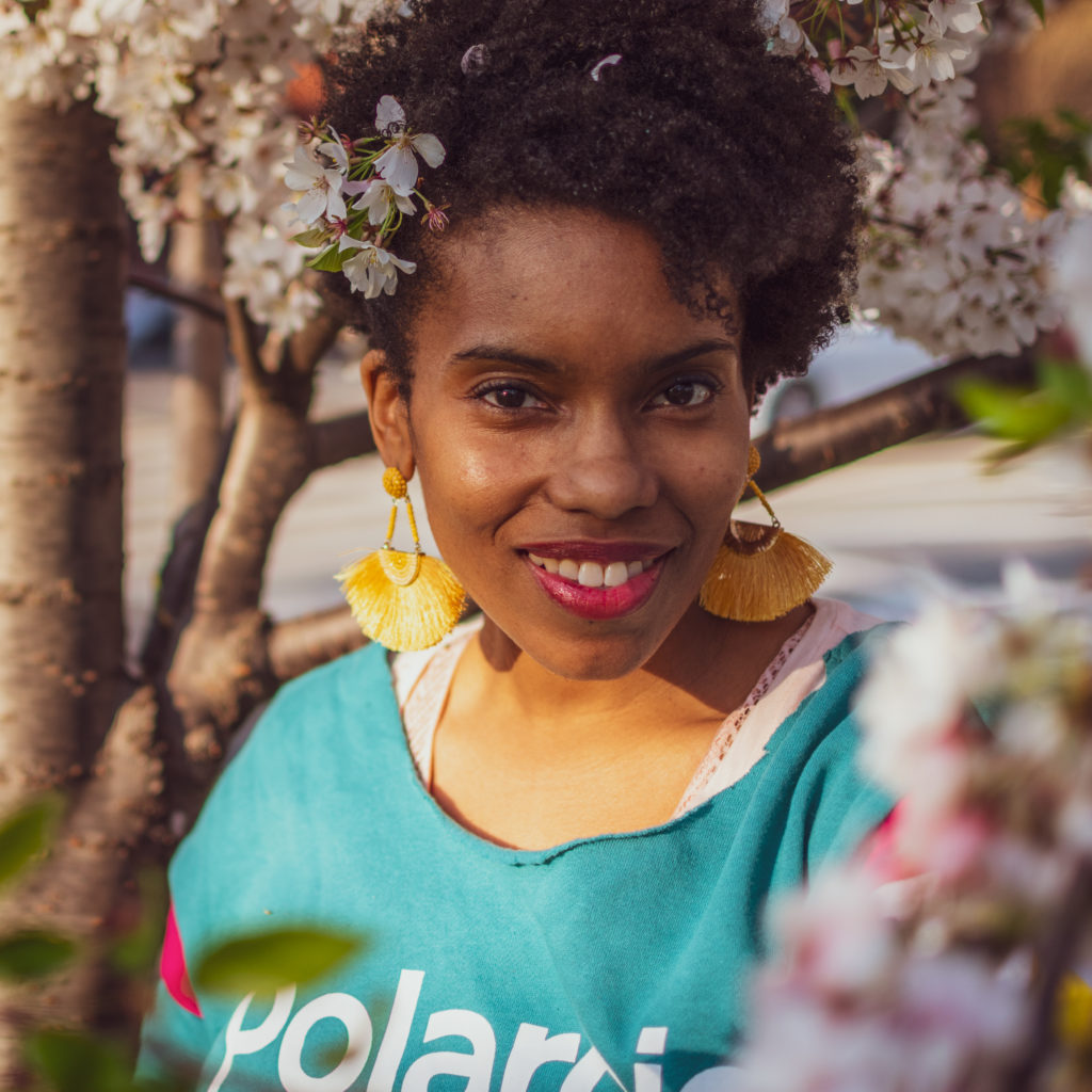 professional headshot - a beautiful black woman poses in front of cherry blossoms in Washington, DC