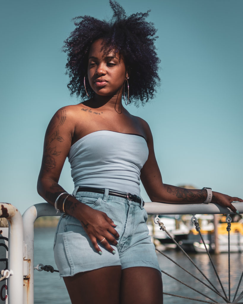 Portrait photography of a beautiful black woman relaxing near the river