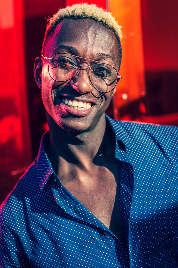 a young model shows off his bright, joyful smile in front of a colorful background