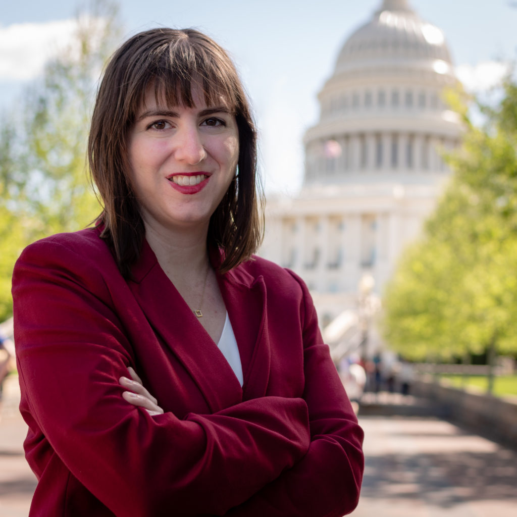 Professional headshot - woman dressed in red stands in front of the United States Capitol in Washington, DC