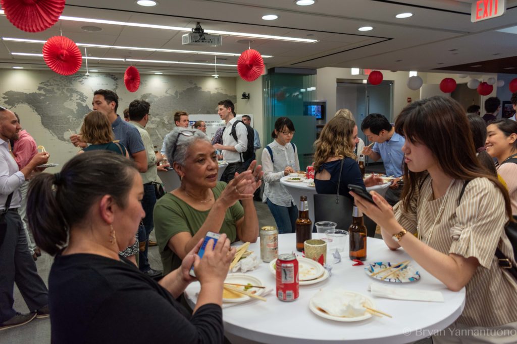 Event photography of a group of people enjoying the food and camaraderie of a party