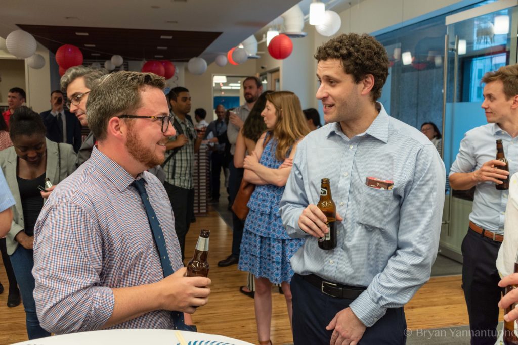 Event photography of two men talking while enjoying a beer