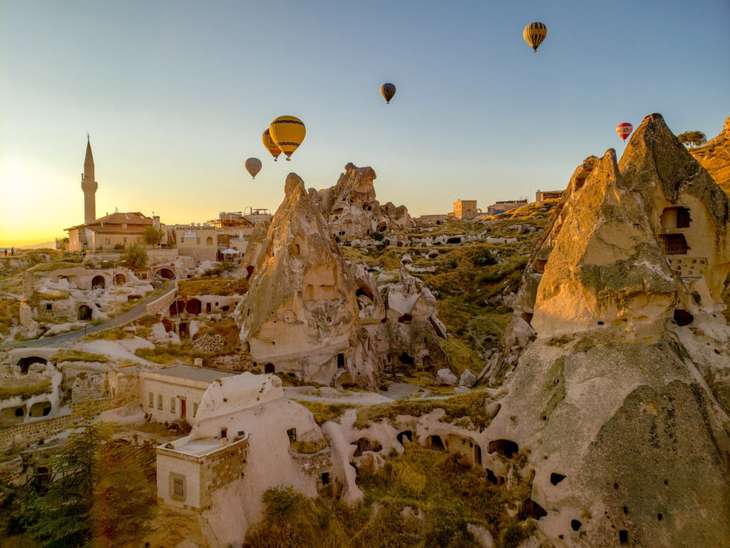 Travel photography of hot air balloons rising over Cappadocia, Turkey at dawn